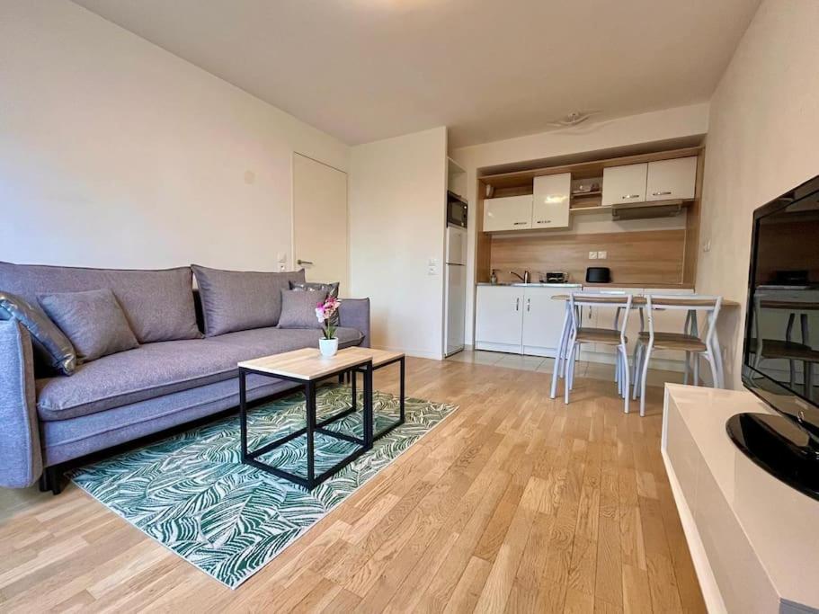 a living room with a purple couch and a table at Logement entier confortable à Créteil in Créteil