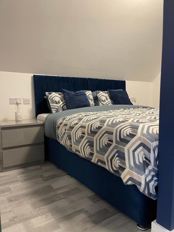 a bedroom with a bed with a blue head board at Lochside Loft - Self Catering Apartment for 2 In a great location for Inverness Airport and both Cabot Highlands & Nairn Golf Courses in Inverness