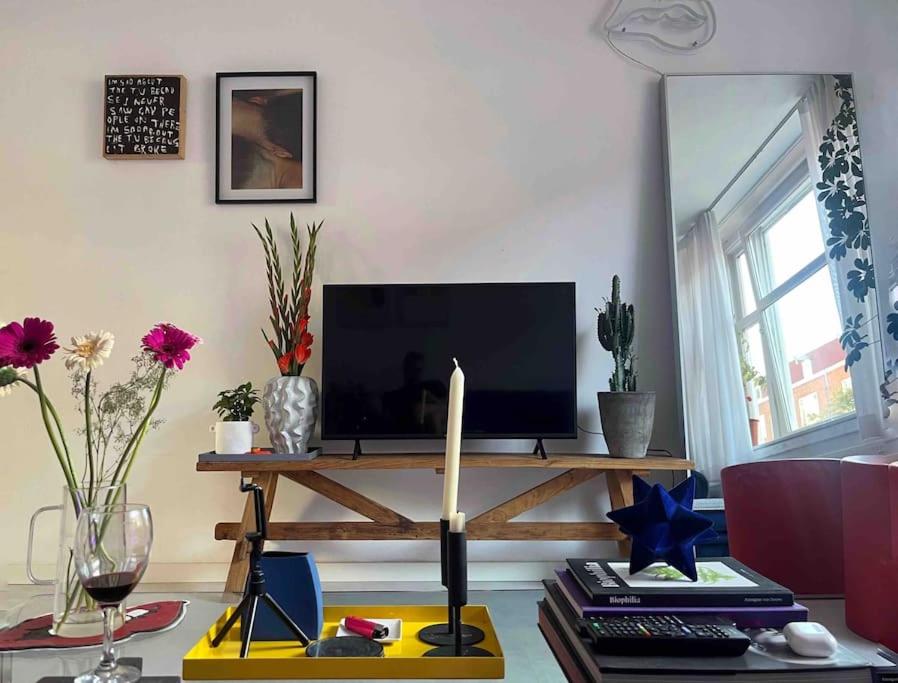 a living room with a table with a tv at Lovely, light and calm 1-bedroom apartment in Amsterdam
