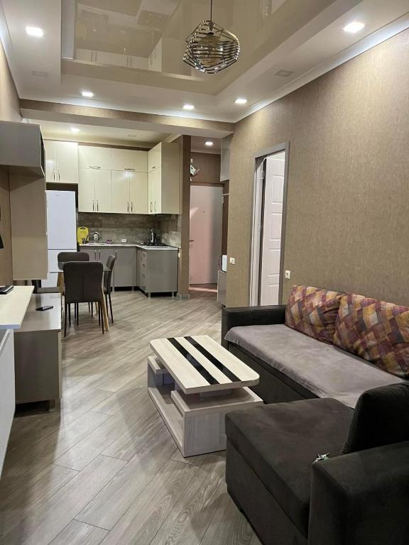 a living room with a couch and a kitchen at vekuas apartments in Tbilisi City