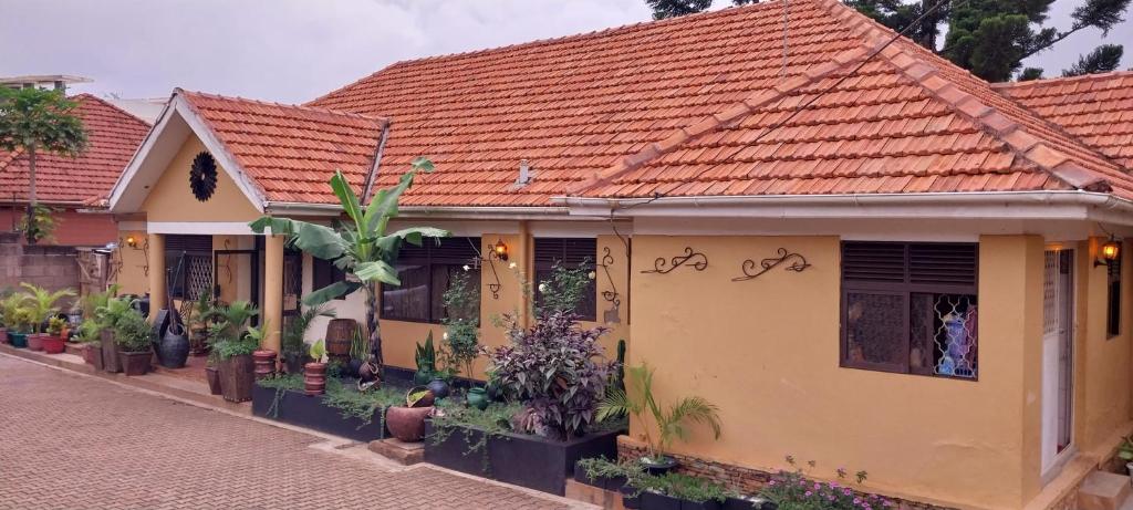 una casa con muchas plantas delante de ella en Naalya Motel en Kampala