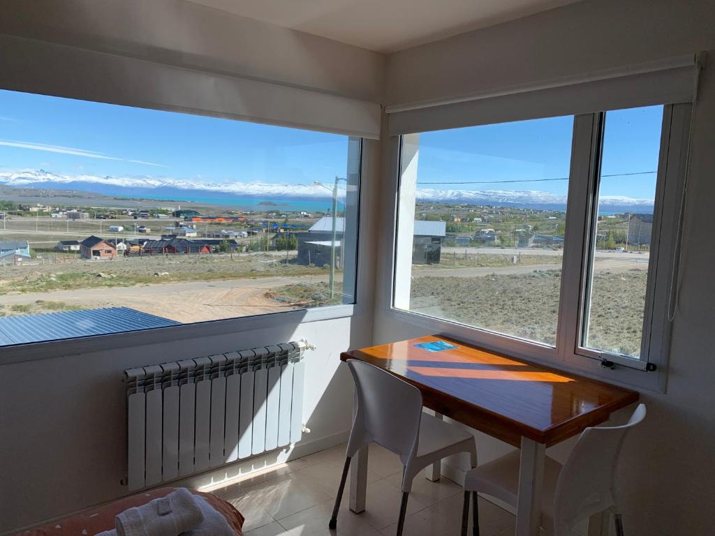 um quarto com uma mesa e uma janela com vista em Go Patagonia! em El Calafate
