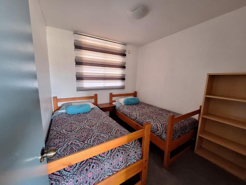 Cette petite chambre comprend 2 lits et une fenêtre. dans l'établissement Departamento diario Copiapo centrico, à Copiapó