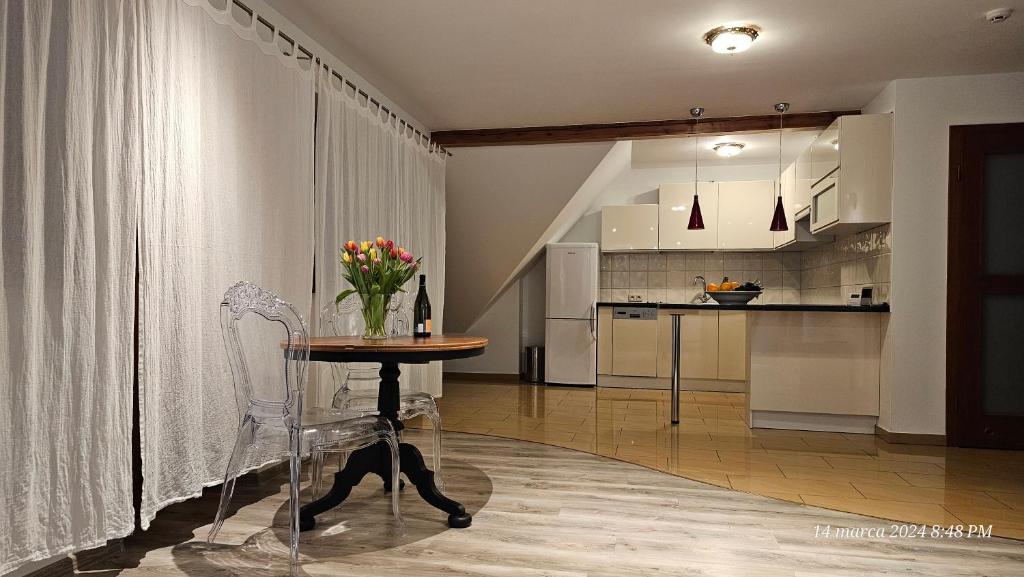 een keuken met een tafel met een vaas met bloemen erop bij Apartament Singera in Biłgoraj