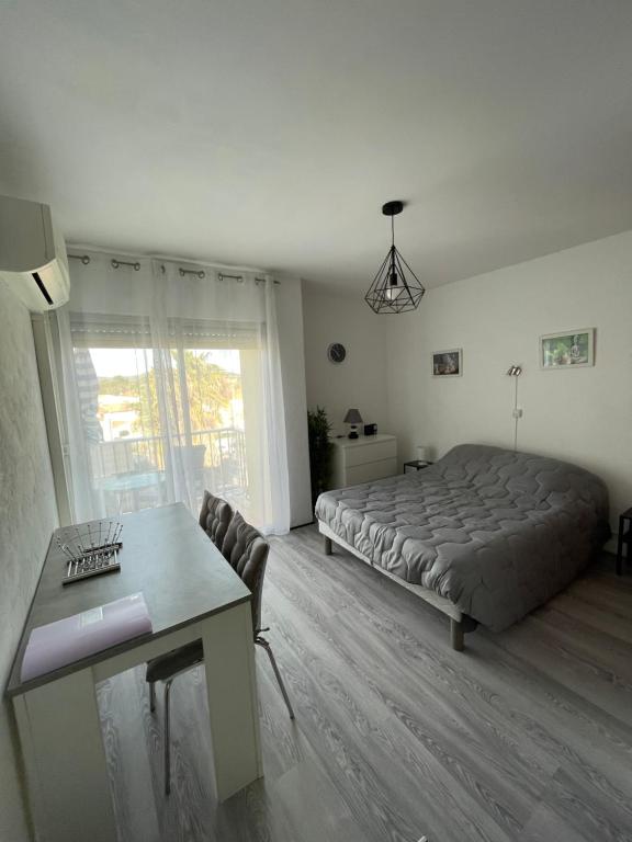 une chambre avec un lit et une table dedans dans l'établissement Studio curistes ou vacances à 300 m des Thermes, à Balaruc-les-Bains