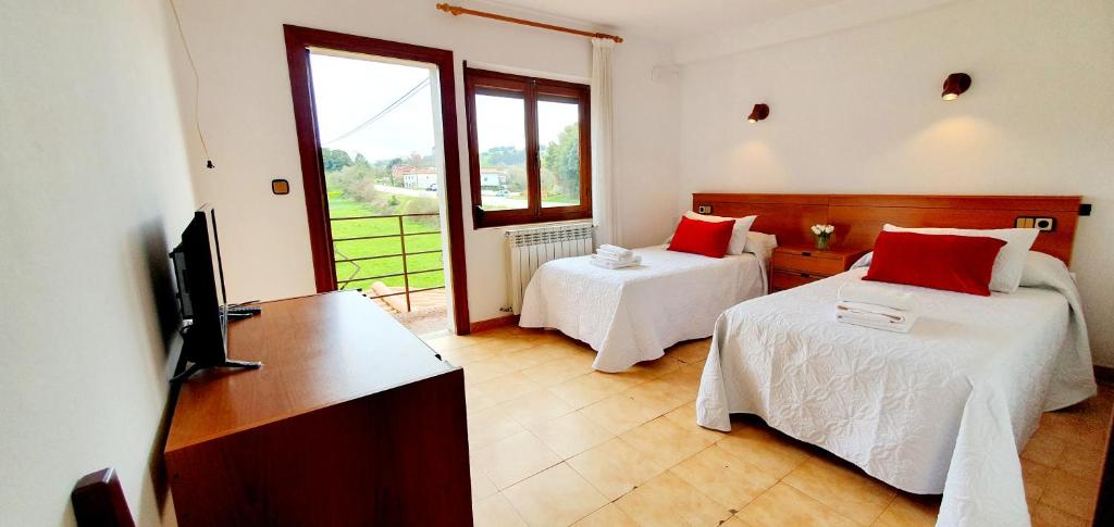 a hotel room with two beds and a television at Sidreria La Casa Abajo in La Franca