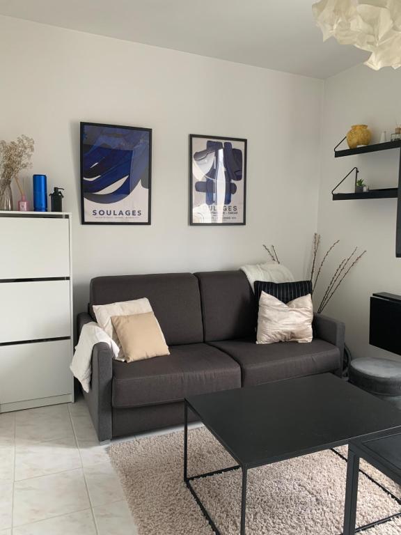 a living room with a couch and a coffee table at Appartement moderne metro 9 in Boulogne-Billancourt