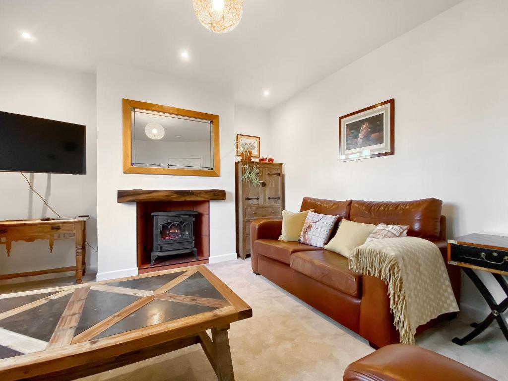 a living room with a couch and a fireplace at Middle Farm Cottage in Avebury