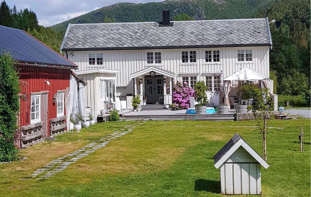 a large white house with a red barn and a yard at Beautiful Home In Kolvereid With Kitchen in Kolvereid