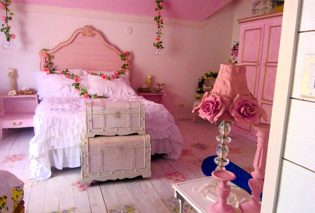 a pink bedroom with a bed with roses on it at Its Day One I Do Bridal Dressing Suite in Nassau
