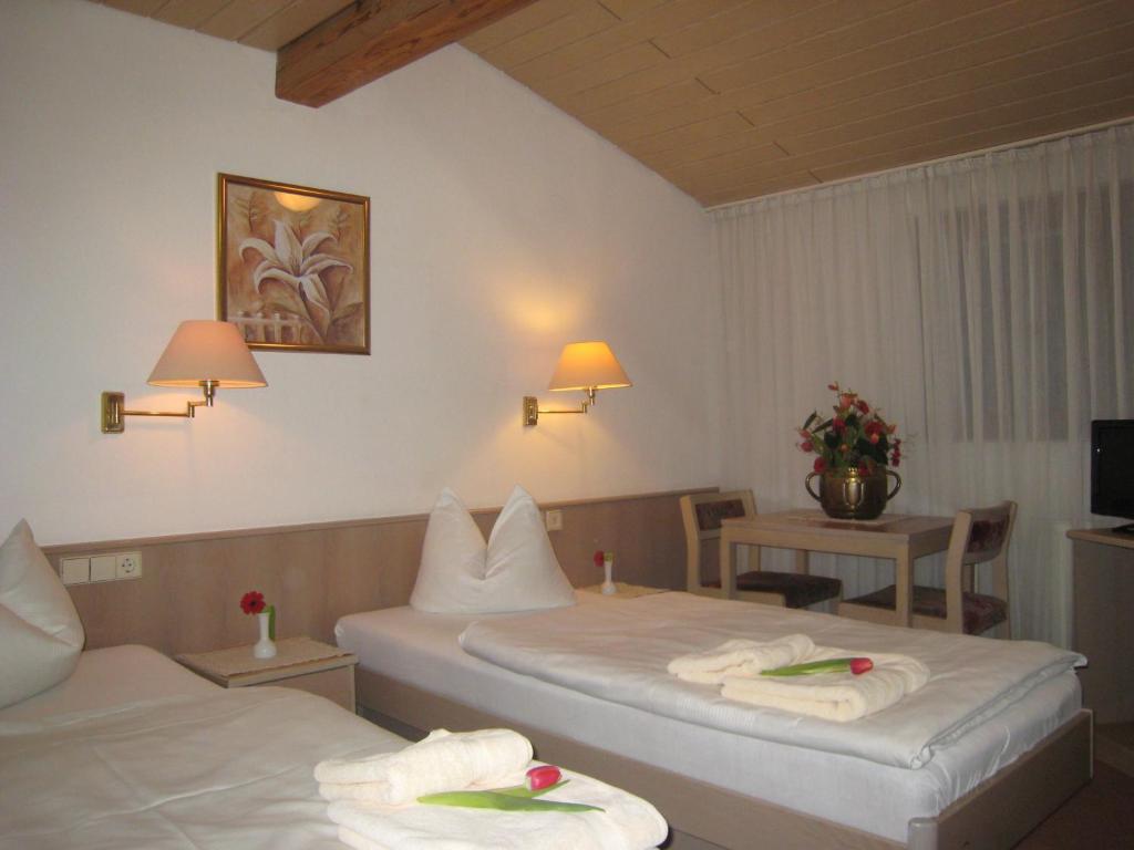 una camera d'albergo con due letti e asciugamani di Zum Flößer a Neckartenzlingen