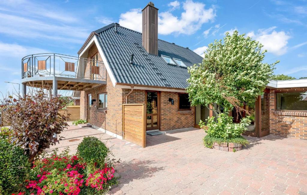 ein Backsteinhaus mit einem Metalldach und einem Balkon in der Unterkunft Cozy Home In Lemvig With Kitchen in Lemvig