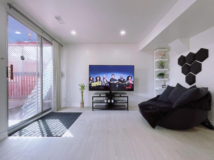 a living room with a flat screen tv on a wall at Private, Spacious Apt Suite w/ Deck Free Parking in Mississauga