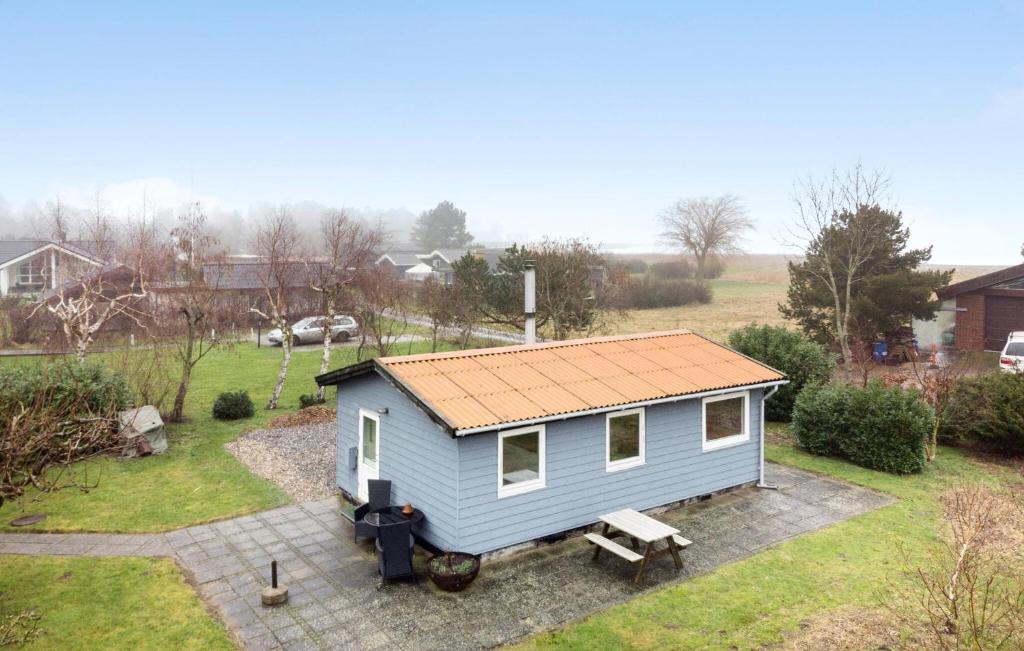 un pequeño cobertizo azul con techo en un patio en Cozy Home In Stubbekbing With Wifi, en Stubbekøbing