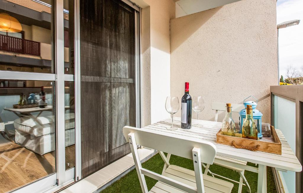 a table with wine bottles and glasses on a balcony at Awesome Apartment In Torre Pacheco With Wifi in Torre-Pacheco