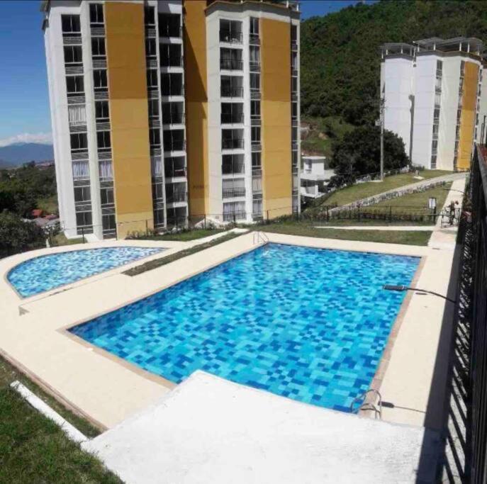 une grande piscine en face d'un bâtiment dans l'établissement Hermoso alojamiento, à Chachagüí