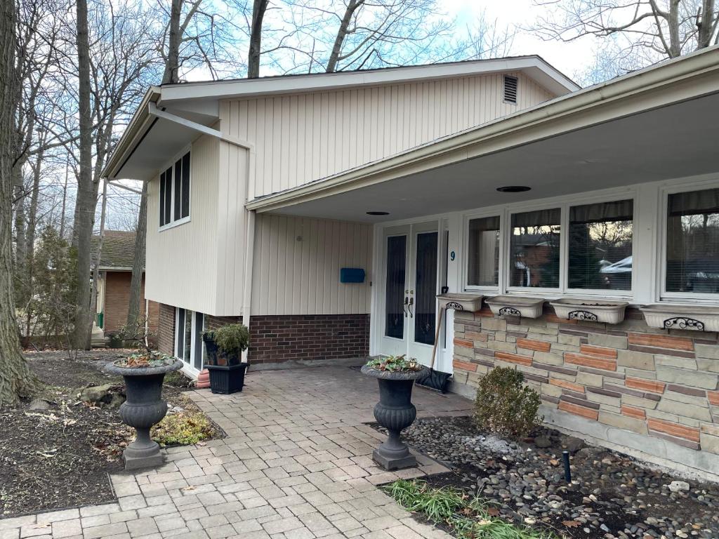 una casa con dos jarrones delante en The Bruce Trail Retreat en St. Catharines