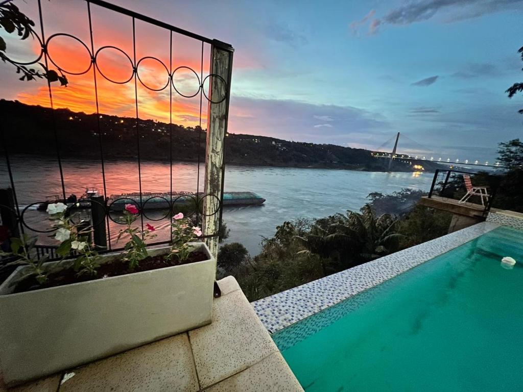 a swimming pool with a view of the water at Puesta del Sol Apart in Puerto Iguazú