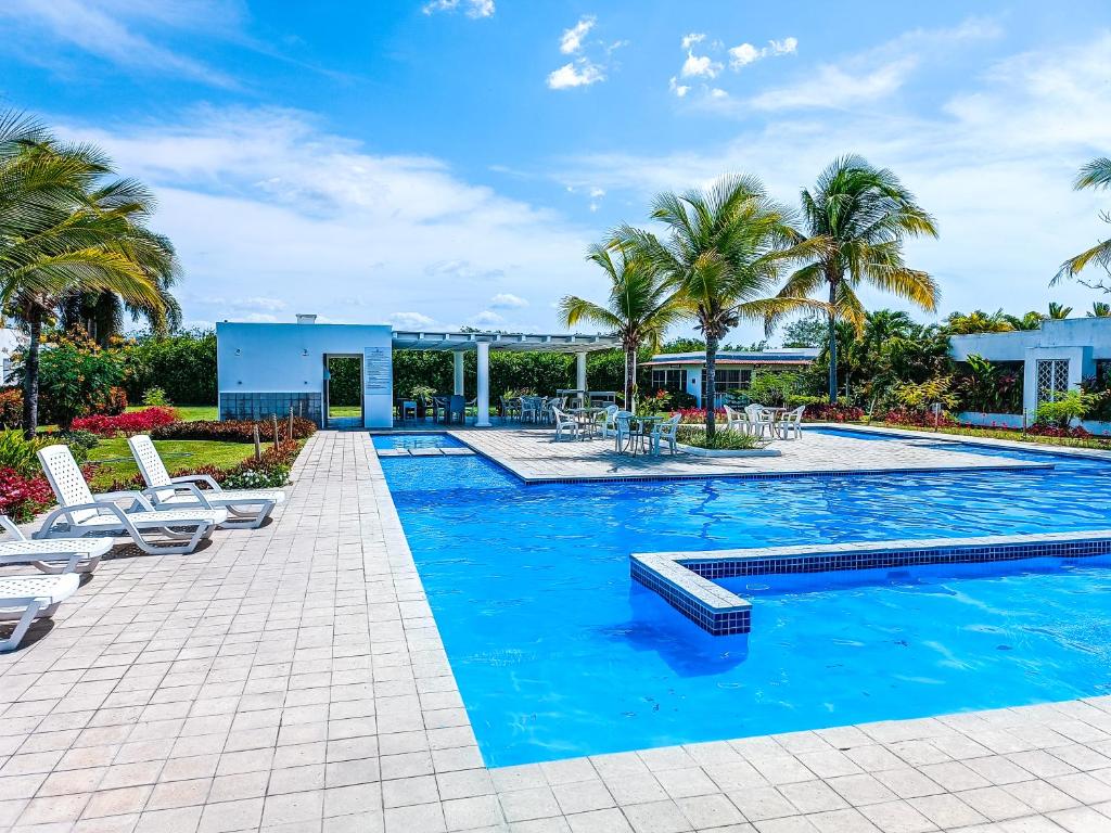 普拉亞布蘭卡的住宿－Villa Superior de Paya，一个带椅子的游泳池,棕榈树