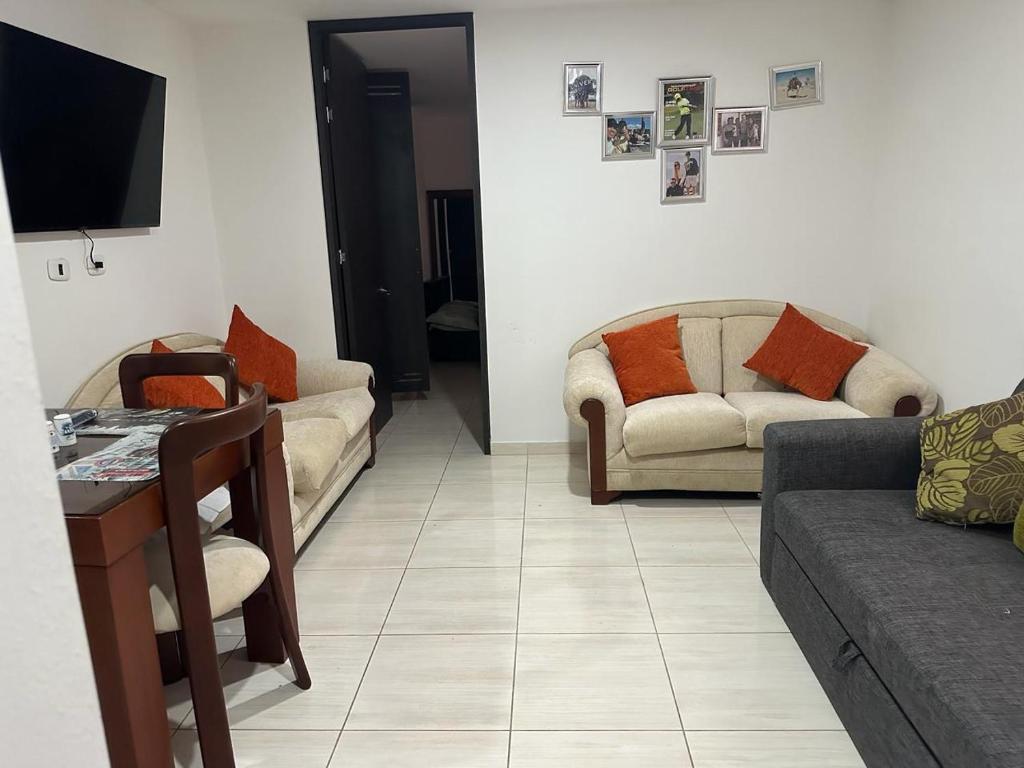 a living room with two couches and a tv at Aparta estudió independiente cerca a la concha acústica (central) in Ibagué