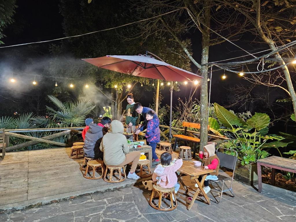 Sapa Jungle Homestay في سابا: مجموعة من الناس يجلسون على الطاولات في مطعم خارجي