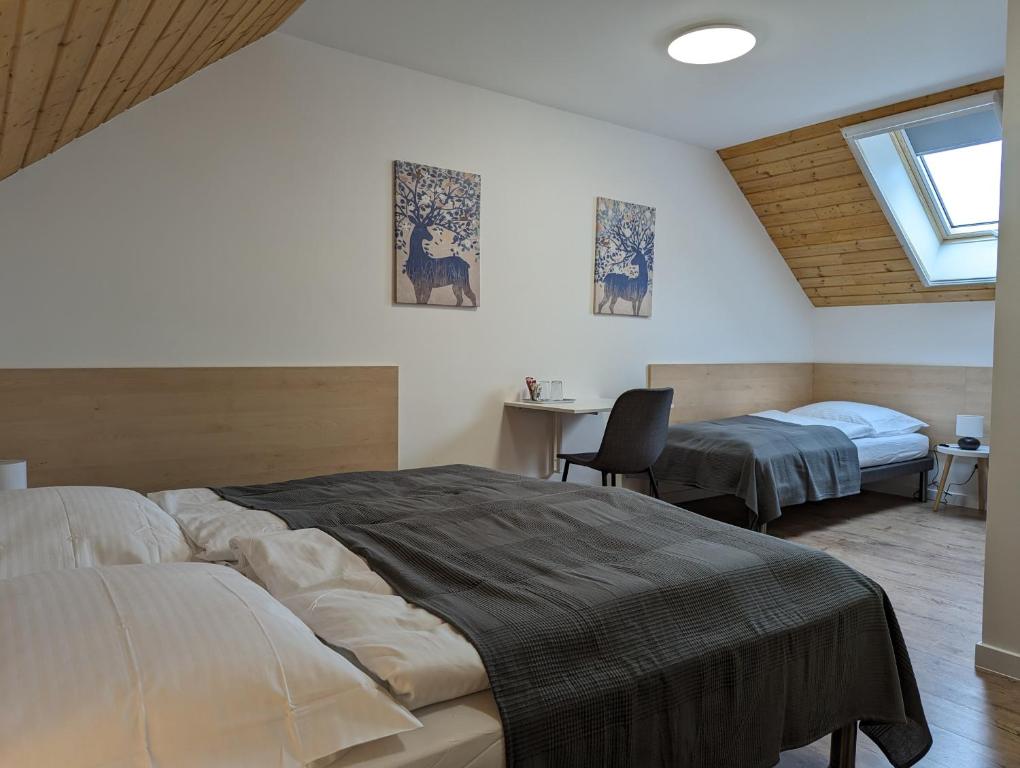 贊卡的住宿－ZánKapu Szálláshely，一间卧室设有两张床、一张桌子和一个窗口。