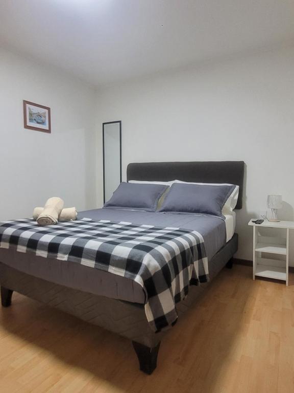 1 dormitorio con 1 cama con manta blanca y negra en C&C TALTAL en Taltal