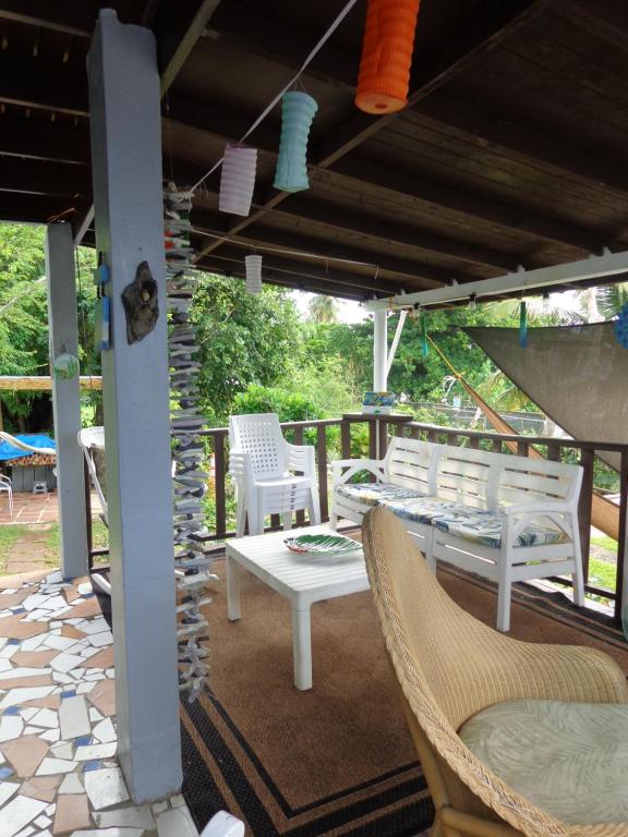 a patio with white chairs and a table and a stone wall at Bungalow Ocean View wifi in Patillas
