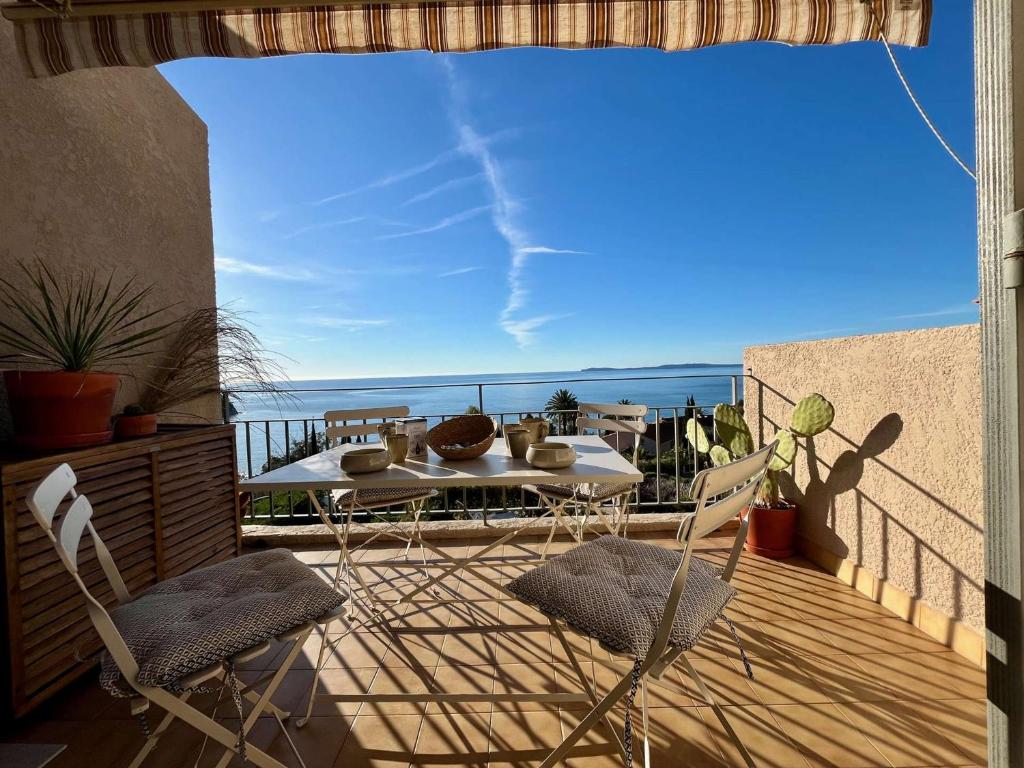 un patio avec une table et des chaises sur un balcon dans l'établissement Appartement T2 Mezzanine, Piscine, Parking, Côte d'Azur - FR-1-226B-189, à Rayol-Canadel-sur-Mer