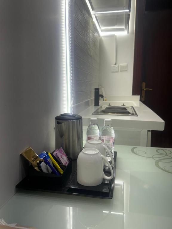 a small refrigerator with a tea kettle and water bottles at جدة in Al Jāmi‘ah