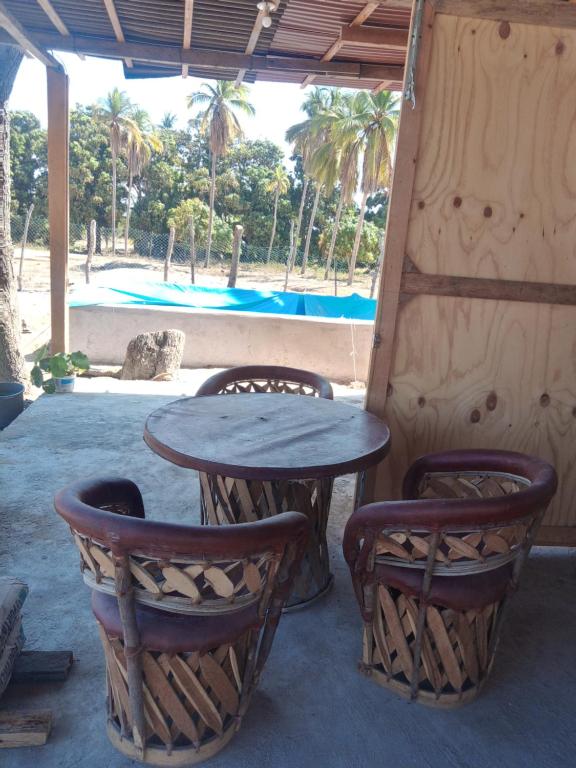 mesa, 2 sillas, mesa y piscina en CASA CERCA DEL MAR ZIHUATANEJO, en El Coacoyul