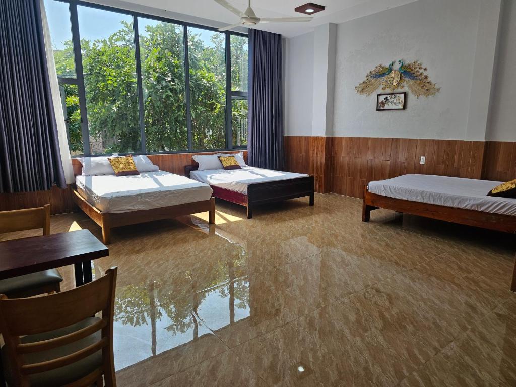 a large room with two beds and a window at Homstay Lynh Lynh Phú Yên in Liên Trì (3)