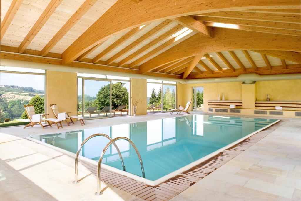 an indoor swimming pool with a wooden ceiling at Relais Montemarino in Borgomale