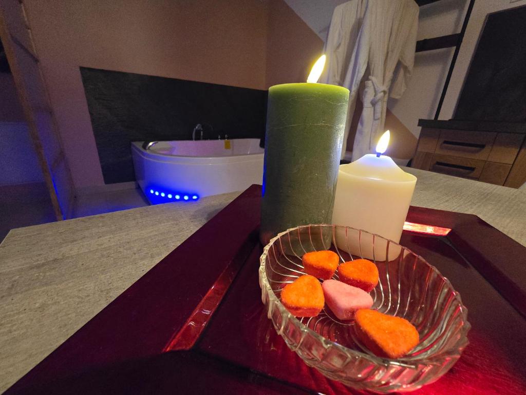 a candle and a bowl of fruit on a table at Suite Love et Evasion in Saint-André-le-Gaz