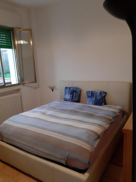 Una cama con almohadas azules en un dormitorio en Ozz Angel, en Ozzano dell'Emilia
