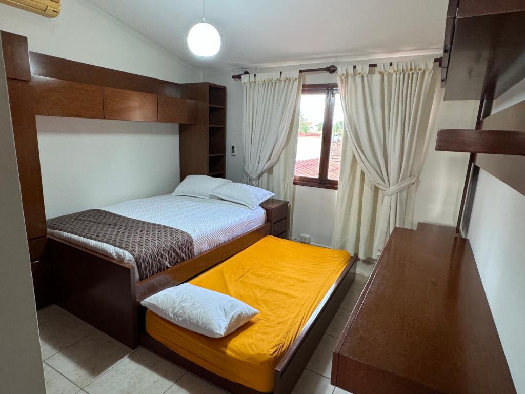 a small bedroom with two beds and a window at Hermosa casa amplia en zona residencial in Santa Cruz de la Sierra