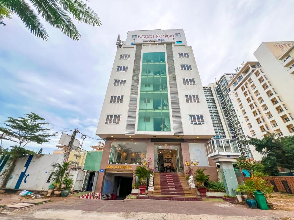 a tall white building with a sign on it at Ngọc Hân Hotel By The Moment in Vung Tau