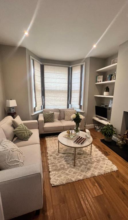 a living room with a couch and a table at Emerald house in London