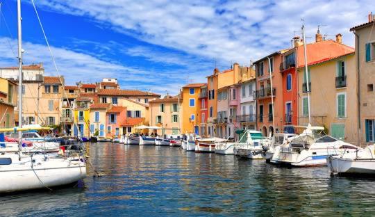 un groupe de bateaux amarrés dans un canal avec des bâtiments dans l'établissement petit coin de paradis, à Martigues