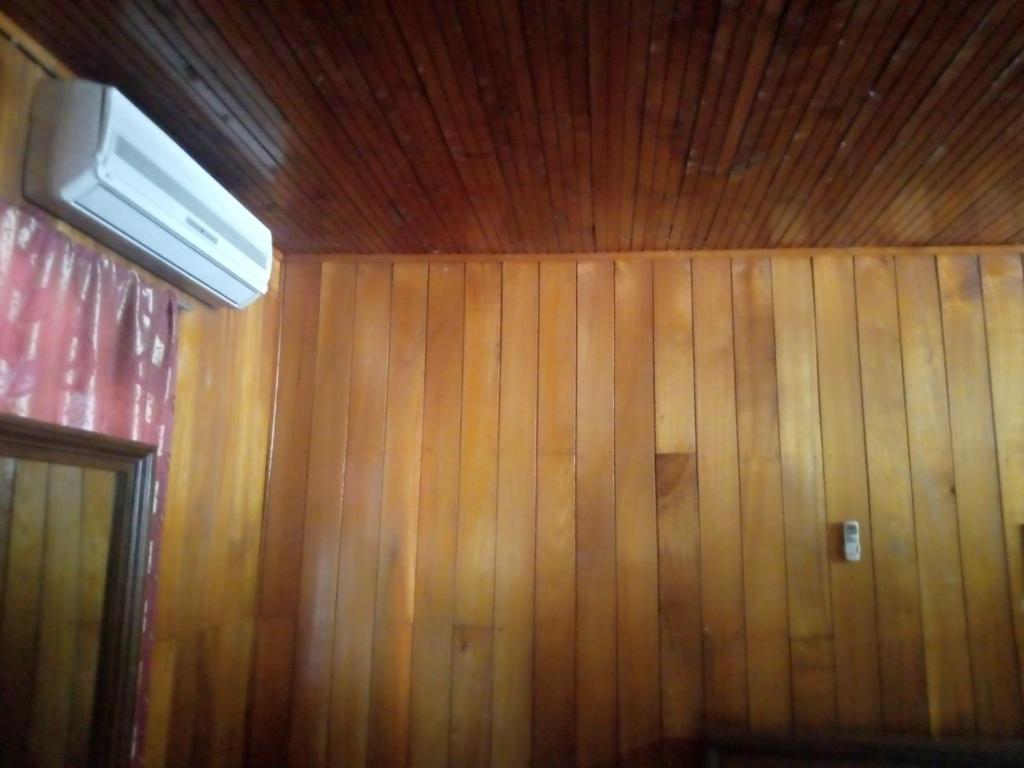 Zimmer mit einer holzgetäfelten Wand und einer Decke in der Unterkunft Maliga Inn in Gampola