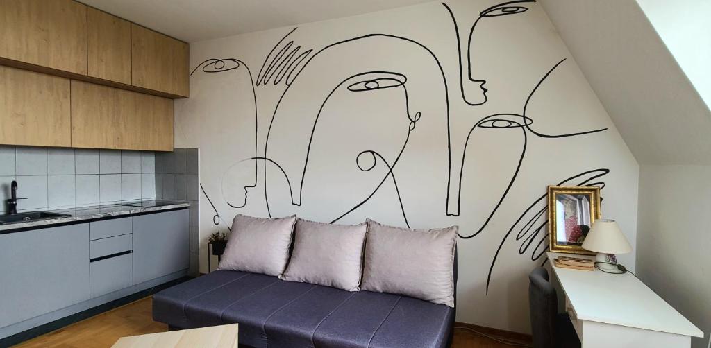 a living room with a purple couch in a kitchen at Cozy studio apartment at center of Bijeljina in Bijeljina