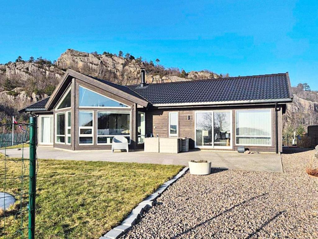 a house with a lot of windows and a mountain at 10 person holiday home in Lindesnes in Spangereid