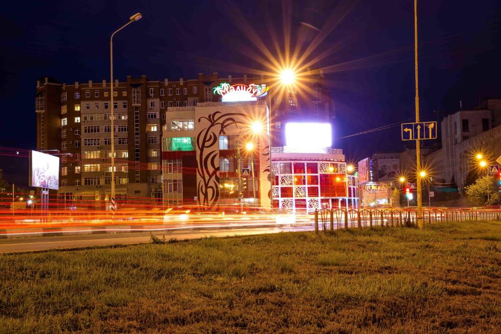 Una ciudad de noche con tráfico en una calle en Malibu Hotel, en Omsk