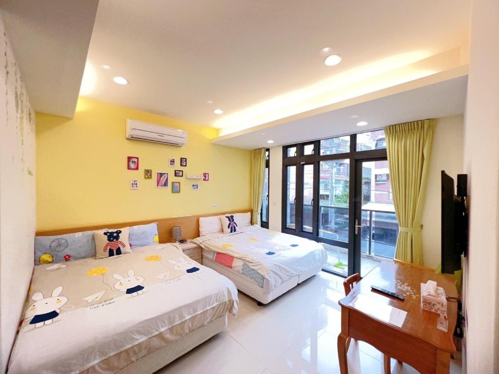 two beds in a room with yellow walls at 享窩民宿 -可包棟 in Jian