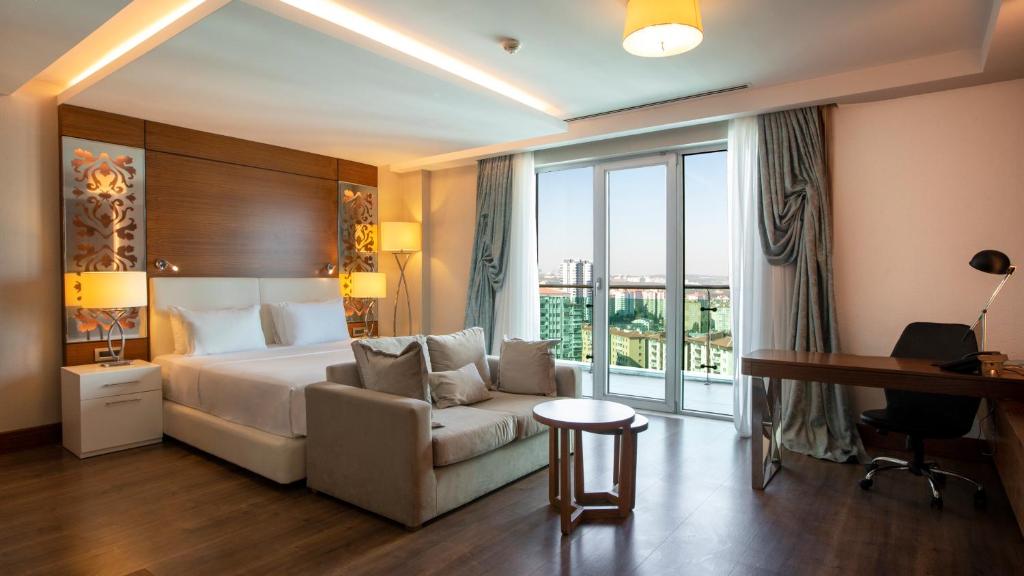 um quarto de hotel com uma cama e um sofá em Holiday Inn Ankara - Cukurambar, an IHG Hotel em Ancara