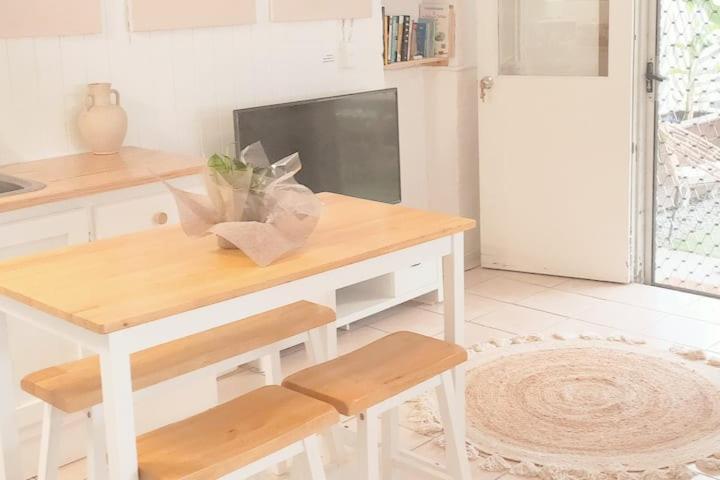 a white kitchen with a table and a tv at Entire Guest Suite - beach is 1 and half km - Pets Welcome in Gold Coast