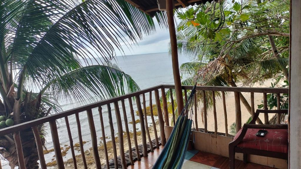 a hammock on a balcony looking at the beach at Sea Esta Beach House in Boljoon