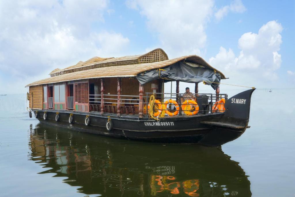 a house boat on the water in the water at St. Mary Houseboat in Kumarakom