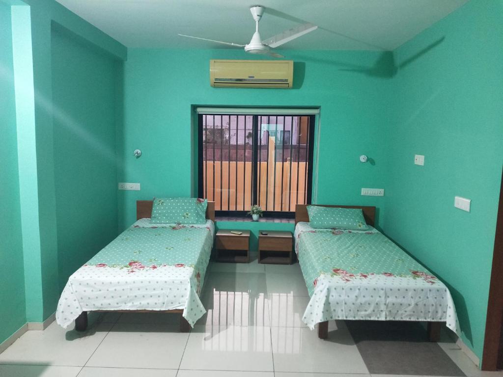 a hospital room with two beds and a window at A Private Room With Terrace in Ahmedabad