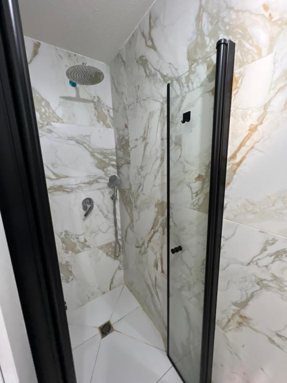 W łazience znajduje się prysznic ze szklanymi drzwiami. w obiekcie סוויטת קריית צאנז w mieście Netanja